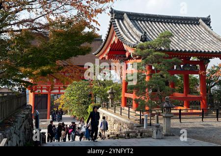 Touristes grimpant les marches à côté du Kiyomizu-dera Shoro (Tour du clocher) et la porte Niomon du célèbre temple bouddhiste à Higashiyama, Kyoto, Japon. Banque D'Images