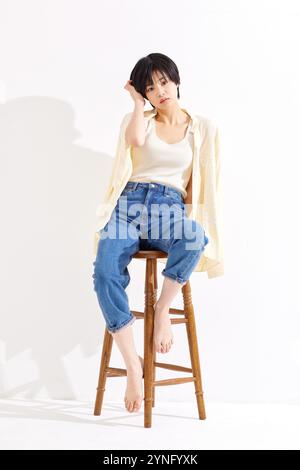 Femme japonaise assise sur un tabouret portant un Jean Banque D'Images