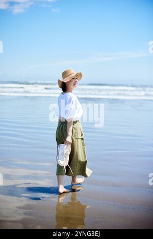 Heureuse jeune femme japonaise à la plage Banque D'Images