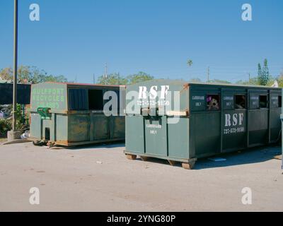 Usage éditorial uniquement le 23 novembre 2024. Gulfport, Floride, États-Unis. Site de collecte des débris endommagés par les tempêtes. Deux benne à roulettes verte sur le trottoir à côté du lampadaire Banque D'Images