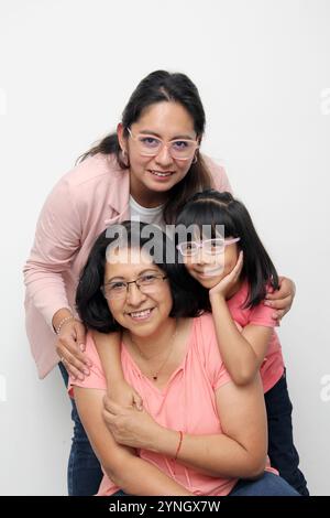 Trois générations de femmes brunes Latina, grand-mère, maman et fille avec des lunettes montrent leur amour et le soutien de leur famille célèbrent la fête des mères Banque D'Images