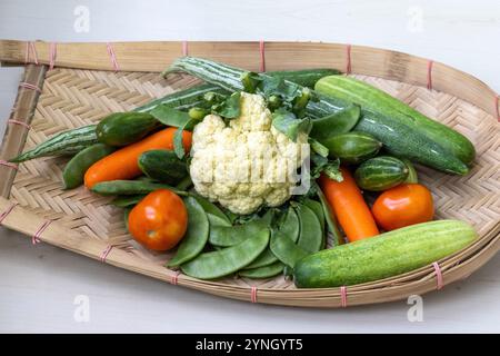 Un kula ou kulo traditionnel tissé en canne de bambou fourré de légumes frais, y compris le chou-fleur, les carottes, le concombre, la gourde de de serpent, piments verts, haricots Banque D'Images