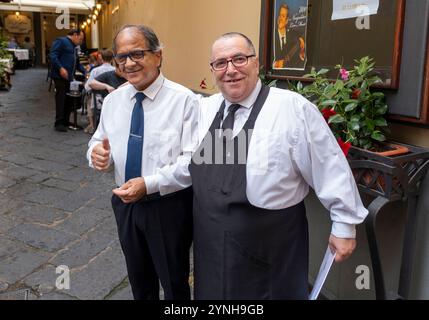 Deux serveurs posent pour la caméra devant un restaurant à Sorrente en Italie Banque D'Images