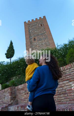 Mère avec enfant visitant une ancienne forteresse musulmane au coucher du soleil lors d'une visite touristique Banque D'Images