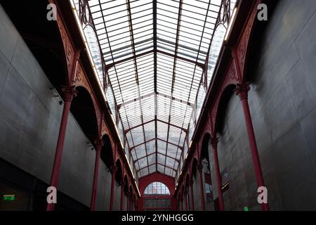 Vue de la façade intérieure avec des colonnes de fer et un toit de verre dans un bâtiment historique à Porto, Portugal, mettant en valeur sty architectural industriel Banque D'Images