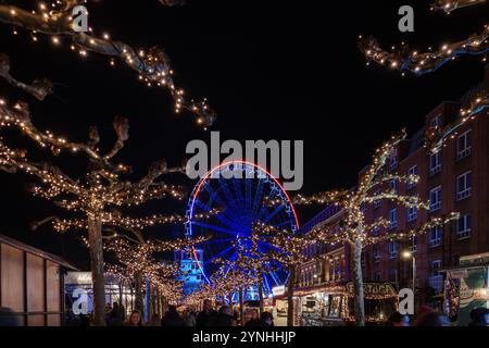 Paysage de nuit sur la promenade et la passerelle le long de la rivière Rhin et étal de marché avec fond de grande roue du marché de Noël, Weihnachts Banque D'Images