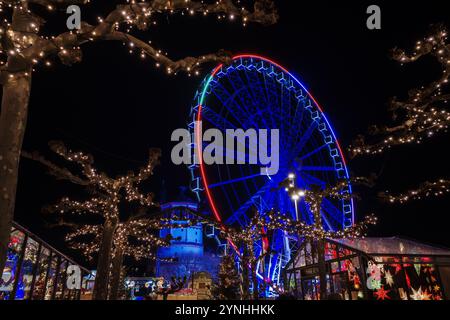 Paysage de nuit sur la promenade et la passerelle le long de la rivière Rhin et étal de marché avec fond de grande roue du marché de Noël, Weihnachts Banque D'Images