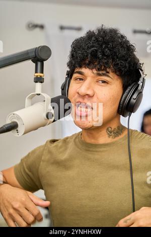 homme latin chantant et enregistrant la chanson avec un microphone Banque D'Images