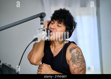 homme latin chantant et enregistrant la chanson avec un microphone Banque D'Images