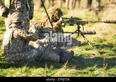 Le prince de Galles, colonel des Welsh Guards, utilise un fusil de sniper lors d'une visite au 1er bataillon Welsh Guards à Salisbury Plain, Wiltshire, pour entendre comment ils sont passés du service cérémonial à l'armée de campagne. Date de la photo : mardi 26 novembre 2024. Banque D'Images