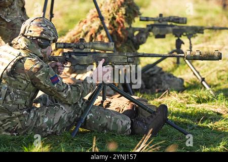 Le prince de Galles, colonel des Welsh Guards, tire un fusil de tireur d'élite lors d'une visite au 1er bataillon Welsh Guards à Salisbury Plain, Wiltshire, pour entendre comment ils sont passés du service cérémonial à l'armée de campagne. Date de la photo : mardi 26 novembre 2024. Banque D'Images