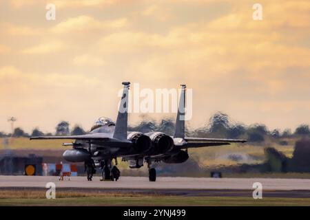 L'équipe au sol travaille avec diligence autour d'un avion de chasse F-15 Eagle sur le tarmac, le préparant pour une mission à venir. L'image met en évidence l'essentiel Banque D'Images