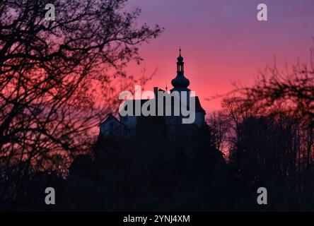 Coucher de soleil avec ciel rouge sur le château à Vysoky Chlumec, République tchèque, 27 décembre 2023. (CTK photo/Petr Lemberk) Banque D'Images