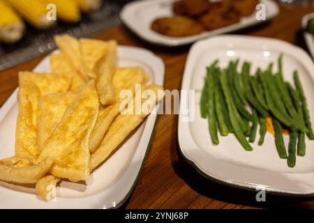Tofu frit croustillant et haricots verts frais sur assiettes en céramique Banque D'Images