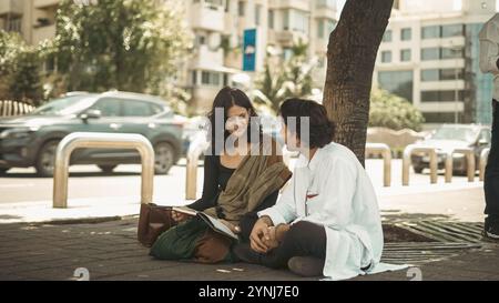 couple assis sous l'arbre profitant de leur anniversaire Banque D'Images