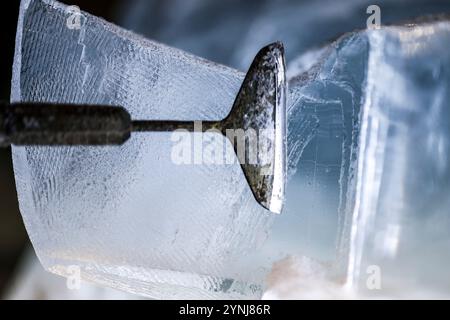 Oberhausen, Allemagne. 26 novembre 2024. Un artiste façonne un bloc de glace avec un grattoir à glace pointu lors d'une exposition de sculptures sur glace et neige, Centro Oberhausen. Crédit : Christoph Reichwein/dpa/Alamy Live News Banque D'Images