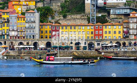 Porto, Portugal - 17 juillet 2024 : réplique d'un bateau rabelo offrant des visites touristiques sur le fleuve Douro, avec le paysage urbain en arrière-plan. Banque D'Images