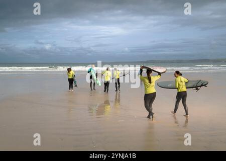 Un instructeur de surf de l'Escape Surf School avec ses apprenants novices de surf au début d'une leçon de surf sur Towan Beach à Newquay à Cornw Banque D'Images