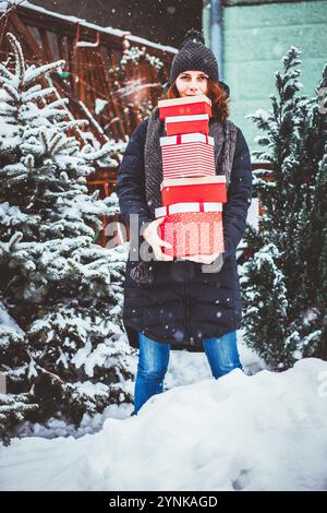 Femme au retour de shopping holding pile de boîtes cadeau de Noël Banque D'Images