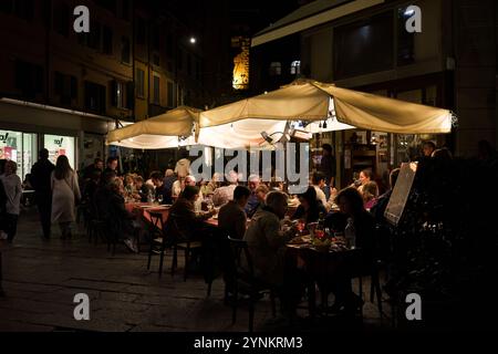 Bologne, Italie. 6 octobre 2024 - les gens dînent tard dans la soirée dans un café extérieur Banque D'Images