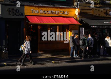 Les gens marchent devant le café du Breakfast Club, Old Compton Street, Soho, Londres, Royaume-Uni. 19 octobre 2024 Banque D'Images