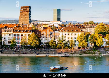 Rangées de maisons sur la rive droite à Kleinbasel et le fameux ferry réaction, un système anachronique mais encore utilisé pour relier les deux rives du R. Banque D'Images