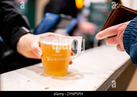 Erfurt, Allemagne. 26 novembre 2024. Un vendeur sert un vin chaud blanc au comptoir du marché de Noël d'Erfurt. Crédit : Jacob Schröter/dpa/Alamy Live News Banque D'Images