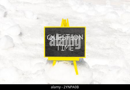Symbole heure des questions. Mots conceptuels heure des questions sur le beau tableau noir de craie jaune. Beau fond de neige blanc. Heure des affaires et des questions co Banque D'Images