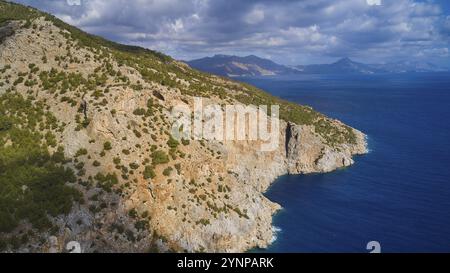 Tir de drone, côte rocheuse avec végétation et vue sur la mer et les montagnes en arrière-plan, tir de drone, côte rocheuse, côte est, Karpathos, Dodec Banque D'Images