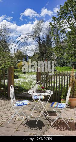 Coin jardin confortable avec table et chaise et une prairie de fleurs en arrière-plan Banque D'Images