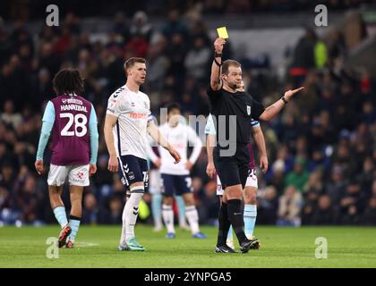 L'arbitre Anthony Backhouse montre un carton jaune à Norman Bassette de Coventry City (non photographié) pendant le match du Sky Bet Championship à Turf Moor, Burnley. Date de la photo : mardi 26 novembre 2024. Banque D'Images