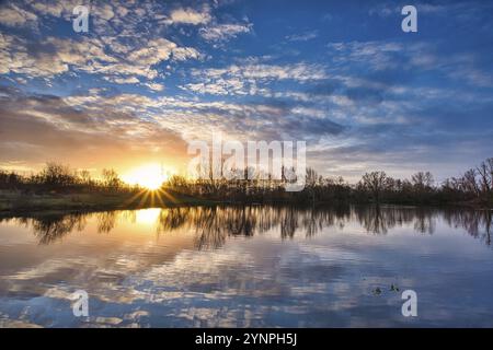 Une belle vue sur le lac étincelant sous le coucher du soleil dans la campagne Banque D'Images