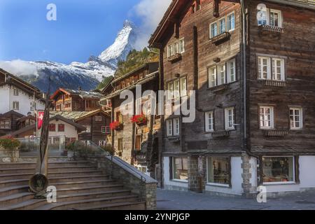 Zermatt, Suisse vue sur la rue de la ville emblématique dans la célèbre station de ski des Alpes suisses, Mont Cervin, Alphorn de bronze et maisons Banque D'Images