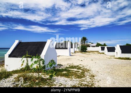 Vue sur les maisons d'esclaves de Bonaire dans les Caraïbes avec un ciel bleu et une mer turquoise Banque D'Images