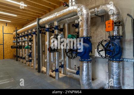 Tuyaux, éléments de contrôle du réservoir de stockage de chaleur d'une usine de biogaz, 5000 mètres cubes d'eau chaude pour l'énergie tampon, pour l'alimentation en chauffage local, Banque D'Images