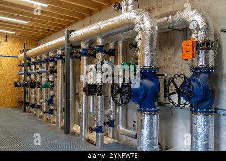 Tuyaux, éléments de contrôle du réservoir de stockage de chaleur d'une usine de biogaz, 5000 mètres cubes d'eau chaude pour l'énergie tampon, pour l'alimentation en chauffage local, Banque D'Images