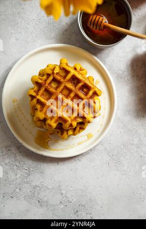 gaufres de citrouille arrosées de miel sur une assiette blanche Banque D'Images