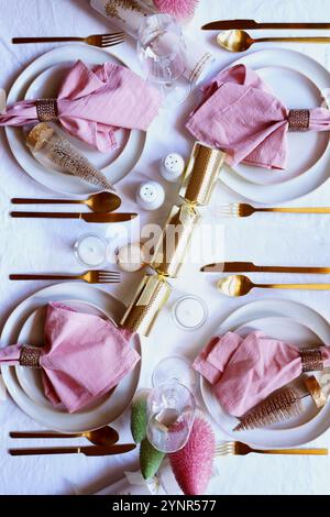Table de Noël dans le thème moderne rose, blanc et or. Banque D'Images