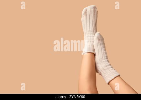 Jambes de jeune femme en chaussettes de coton sur fond brun Banque D'Images