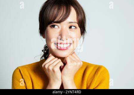 Portrait de femme souriante de 20-quelque chose avec la main sur le menton Banque D'Images