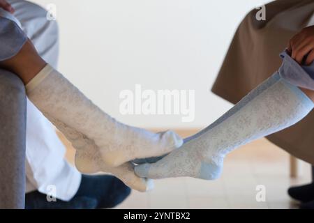 Soeurs avec les jambes ensemble sous la table Banque D'Images