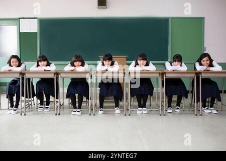 Filles assises dans une rangée de bureaux Banque D'Images