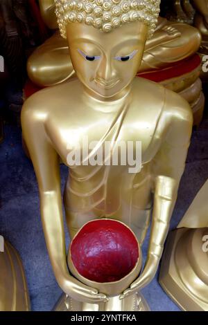 Statue de Bouddha comme un moine tenant un bol d'aumônes. Dans une usine de statues bouddhistes à Bamrung Muang Road, Phra Nakhorn, Bangkok, Thaïlande Banque D'Images