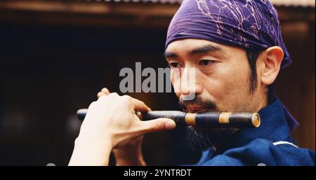 Homme japonais, flûte et musique pour la tradition, performance et son zen pour la méditation shinto. Sensei personne, bambou et instrument FUE pour la pratique Banque D'Images