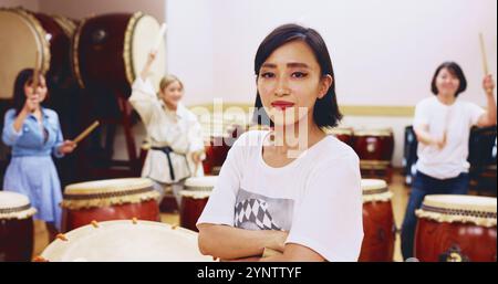 Japonais, batterie et femme en portrait pour musique sur instrument pour performance, créativité ou classe. Taiko, des gens ou des femmes battrices apprenant dans le groupe Banque D'Images