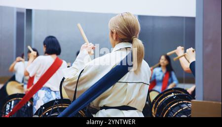 Japonais, dos et les gens avec des tambours pour la musique sur instrument pour la performance, la pratique et la classe. Taiko, des femmes ou des femmes battrices apprenant dans le groupe à Banque D'Images