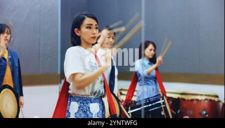 Japonais, l'apprentissage et les gens avec des tambours pour la musique sur instrument pour la performance, la pratique et la classe. Taiko, femmes ou batteurs féminins dans le groupe à jouer Banque D'Images