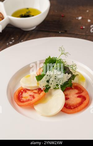 Salade de tomates et mozzarella sur une assiette en porcelaine blanche, salade Caprese Banque D'Images