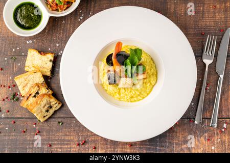 Risotto aux fruits de mer, risotto alla pescatora, servi dans une assiette en porcelaine blanche Banque D'Images