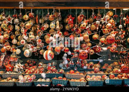 Boules de Noël fabriquées à la main en rouge, or et blanc, disposées dans des paniers en osier et accrochées à un marché de Noël européen traditionnel de Vienne. Banque D'Images